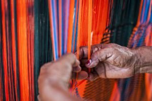 Mujer tejiendo un "chinchorro" o hamaca colombiana, en el pueblo de Uribia. Tejer, tejer y tejer son fundamentales para la vida social y económica de las mujeres Wayuu en La Guajira, Colombia.