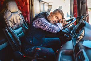 Conductor de camión exhausto quedándose dormido en el volante.