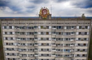 The rusty emblem of the Soviet Union is seen on the roof of an apartment building in the ghost town of Pripyat close to the Chernobyl nuclear plant, Ukraine, Thursday, April 15, 2021. The vast and empty Chernobyl Exclusion Zone around the site of the world’s worst nuclear accident is a baleful monument to human mistakes. Yet 35 years after a power plant reactor exploded, Ukrainians also look to it for inspiration, solace and income. (AP Photo/Efrem Lukatsky)