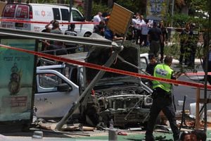 Miembros del personal de seguridad y emergencia israelí trabajan en el sitio de un ataque de embestida de automóvil en Tel Aviv el 4 de julio de 2023. (Photo by JACK GUEZ / AFP)