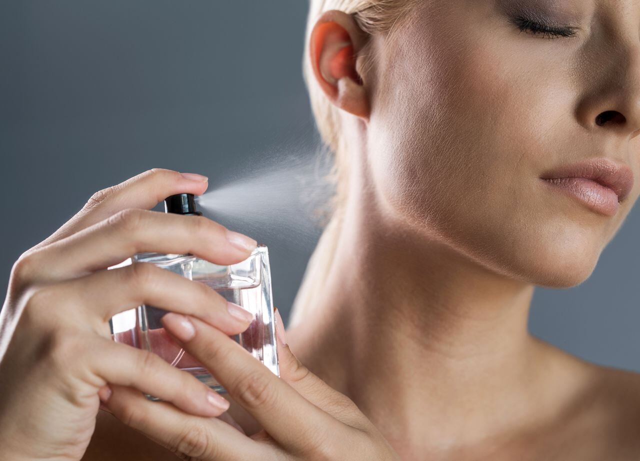 Close up of a beauty woman applying perfume.