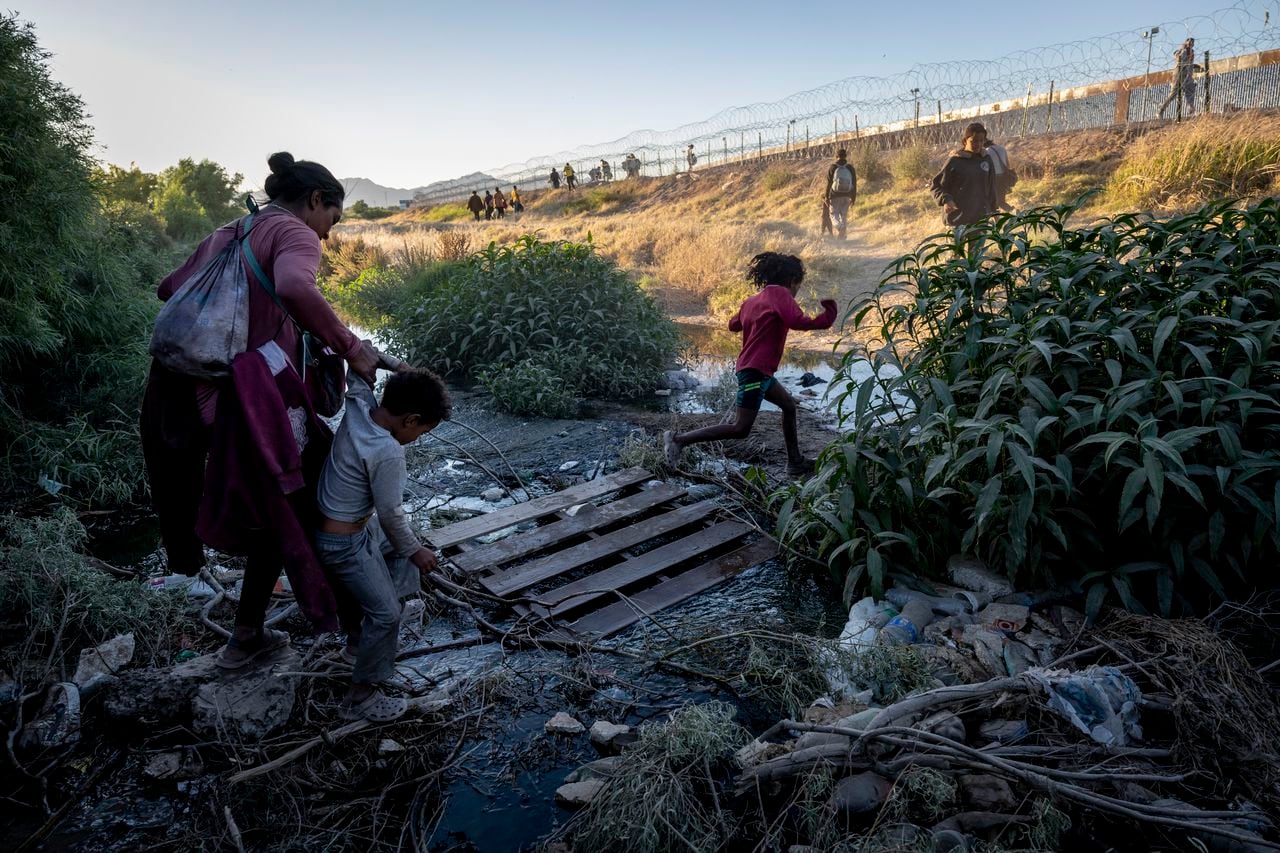Inmigrantes cruzan un hilo del Río Grande mientras cruzan la frontera desde México con la esperanza de ser procesados para asilo el 8 de mayo de 2023 en El Paso, Texas.