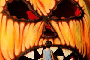Un niño mira una calabaza gigante de Halloween hecha de papel maché en La Valeta, Malta, el 24 de octubre de 2022. 