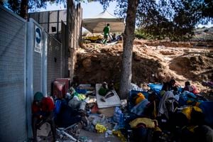 Los migrantes se reúnen frente al centro operativo llamado "Hotspot" en la isla italiana de Lampedusa el 15 de septiembre de 2023. El centro de recepción de la isla, construido para albergar a menos de 400 personas, estaba abrumado por hombres, mujeres y niños obligados a dormir al aire libre sobre plástico improvisado. catres, muchos de ellos envueltos en mantas metálicas de emergencia. El buen tiempo ha provocado un aumento en las llegadas a Italia en los últimos días: más de 5.000 personas desembarcaron en todo el país el 12 de septiembre y casi 3.000 el día siguiente, según cifras actualizadas del Ministerio del Interior.