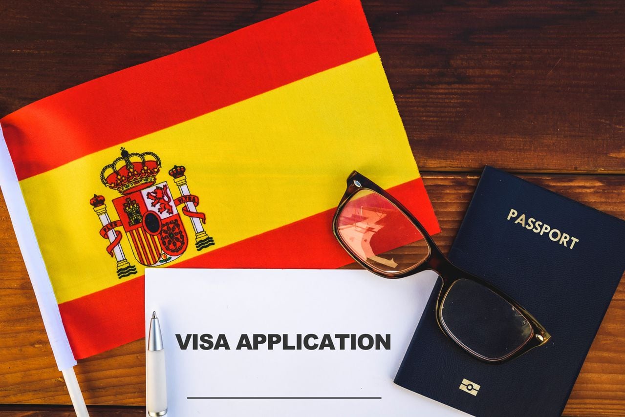 Flag of Spain , visa application form and passport on table