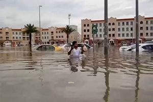 In this video grab from AFPTV, a man wades through a flooded street in Dubai on April 16, 2024. Dubai, the Middle East's financial centre, has been paralysed by the torrential rain that caused floods across the UAE and Bahrain and left 18 dead in Oman on April 14 and 15. (Photo by ATIF BHATTI / ESN / AFP) / RESTRICTED TO EDITORIAL USE � MANDATORY CREDIT - AFP PHOTO / ATIF BHATTI / ESN  - NO MARKETING NO ADVERTISING CAMPAIGNS � DISTRIBUTED AS A SERVICE TO CLIENTS -NO ARCHIVE -