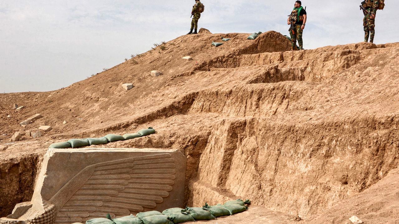 Las fuerzas de seguridad iraquíes montan guardia en el sitio de una escultura de alabastro asirio Lamassu (toro alado con cabeza humana) recién desenterrada con todas sus alas intactas por la misión arqueológica francesa en el sitio arqueológico de Khorsabad.