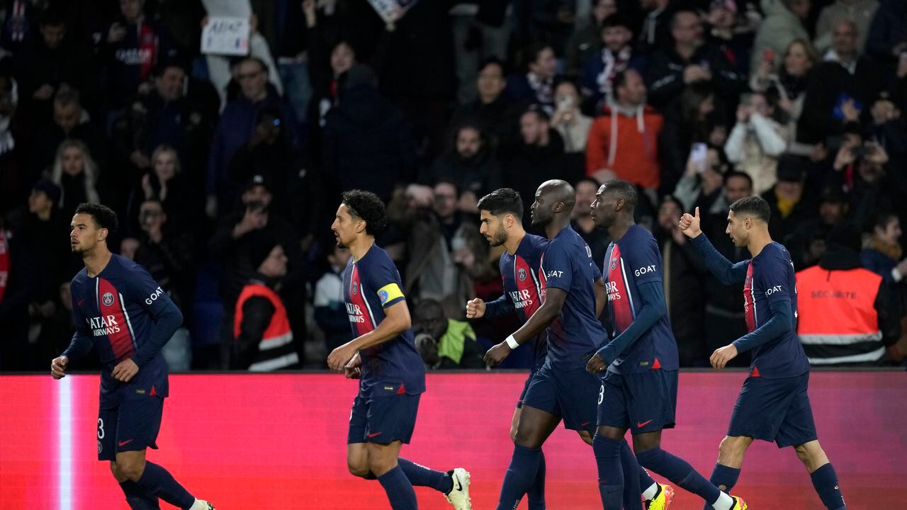 Los jugadores del PSG celebran el primer gol de su equipo durante el partido de fútbol de la Liga Francesa Uno entre Paris Saint-Germain y Lyon en el estadio Parc des Princes de París, el domingo 21 de abril de 2024. (Foto AP/Christophe Ena)