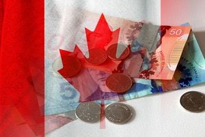 Canadian dollar cash bills and coins and flag of Canada (money, economy, business, finance, inflation, crisis)