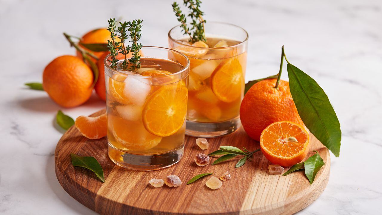 Ice tea with orange juice, ice cubes, and thymes. Refreshed cold spring and summer citrus beverage.