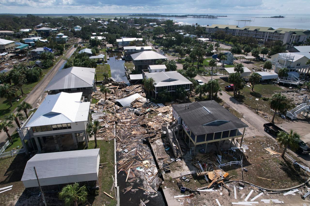 En esta fotografía tomada con un dron, los escombros de las casas arrastradas por la corriente se encuentran esparcidos alrededor de las casas sobre pilotes que sobrevivieron, en Horseshoe Beach, Florida, el jueves 31 de agosto de 2023, un día después del paso del huracán Idalia. (Foto AP/Rebecca Blackwell)