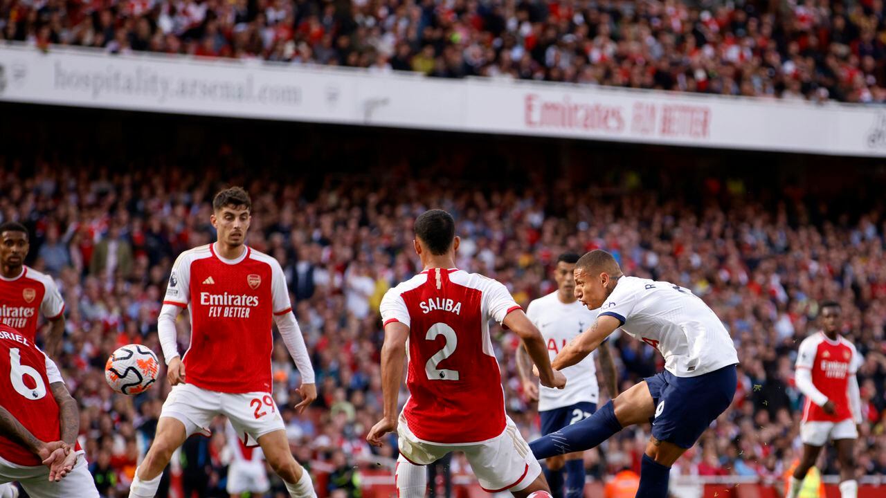 Richarlison, del Tottenham, a la derecha, intenta un tiro a portería durante el partido de fútbol de la Liga Premier inglesa entre Arsenal y Tottenham Hotspur en el estadio Emirates de Londres, Inglaterra, el domingo 24 de septiembre de 2023. (Foto AP/David Cliff)