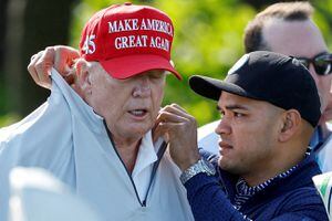 Walt Nauta, asistente personal del expresidente de EE. UU. Donald Trump que enfrenta cargos de ser co-conspirador de Trump en el supuesto mal manejo de documentos clasificados, arregla el collar de Trump antes de un torneo de golf LIV Golf Pro-Am en el Trump National Golf Club en Sterling, Virginia