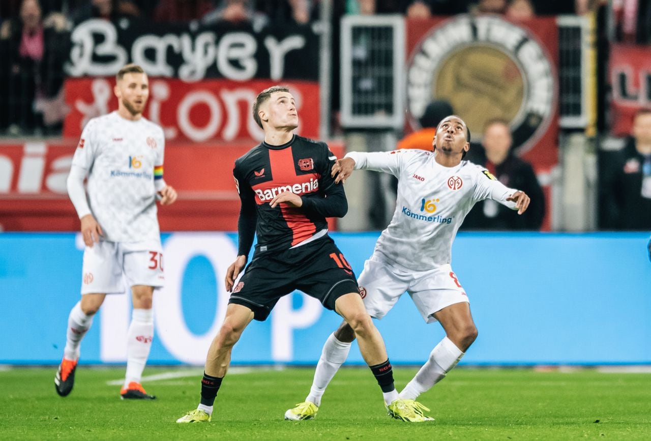 Bayer 04 Leverkusen (izq.) en acción contra Karim Onisiwo (dcha.) del FSV Mainz 05 durante el partido de fútbol de la Bundesliga entre Bayer 04 Leverkusen y FSV Mainz 05 en el BayArena de Leverkusen, Alemania, el 23 de febrero de 2024.