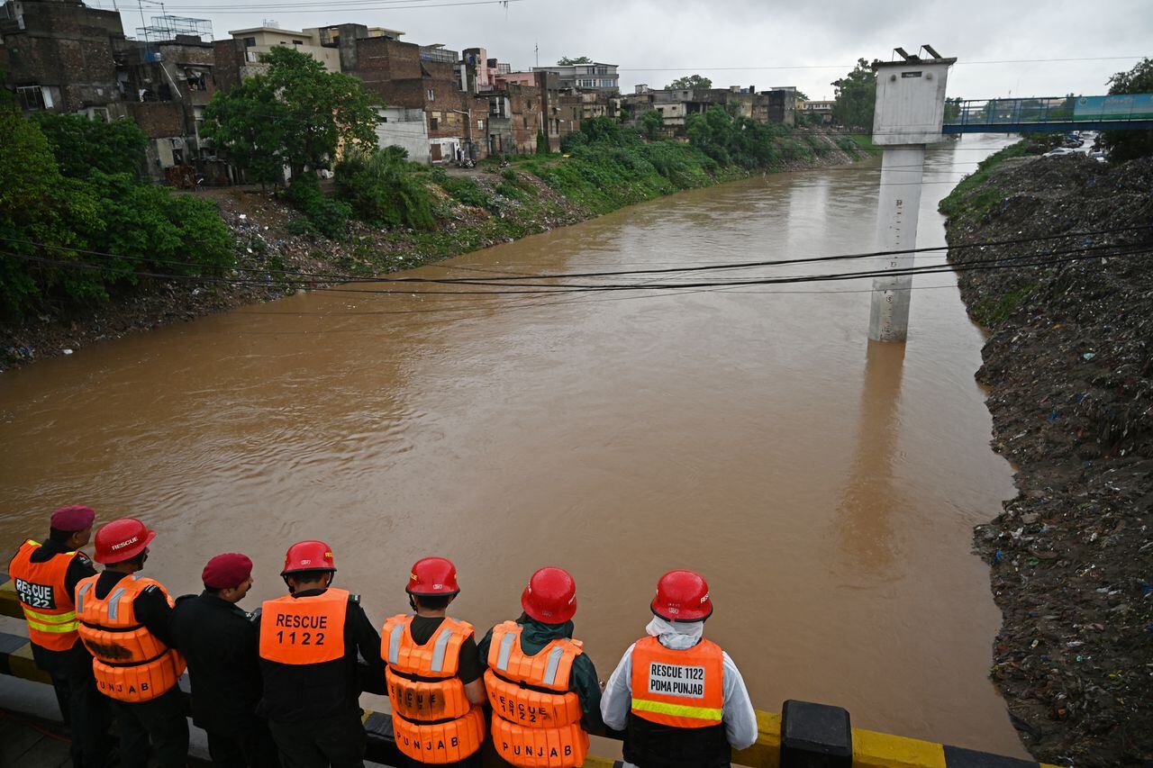 Los equipos de rescate monitorean la situación de la inundación desde un puente construido sobre un arroyo en Rawalpindi el 19 de julio de 2023. Más de 14,000 personas y su ganado fueron evacuados de aldeas en el este de Pakistán, dijeron las autoridades el 18 de julio
