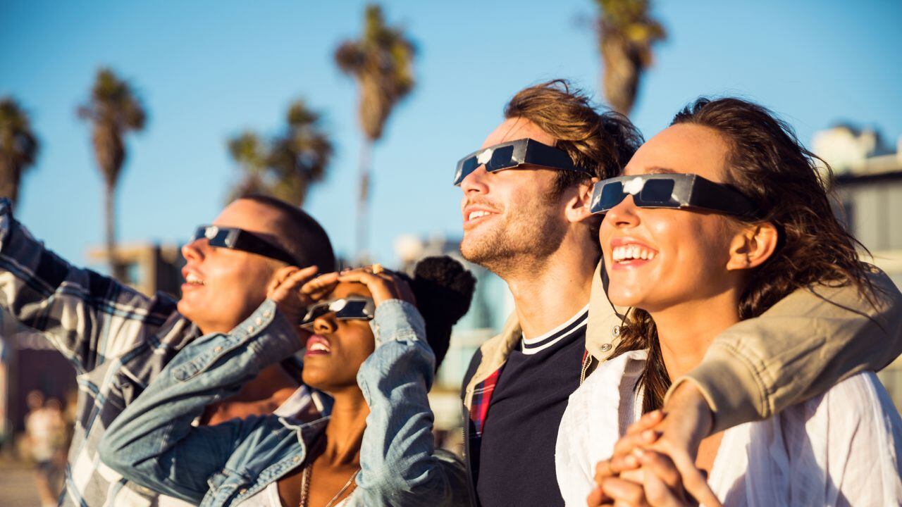 Personas con gafas especiales para ver un eclipse solar.