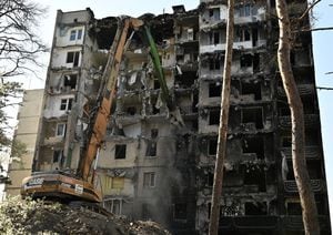 Los trabajadores desmantelan un edificio residencial gravemente dañado en la ciudad de Irpin. Foto: AFP.