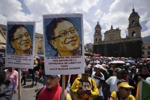 A demonstrator carries posters of President Gustavo Petro during a march in support of his government's proposed reforms in Bogota, Colombia, Wednesday, Sept. 27, 2023. The poster reads in Spanish "The government of change gives us back hope for the release of David Murcia Guzman," referring to a Colombian arrested for financial crimes. (AP Photo/Fernando Vergara)