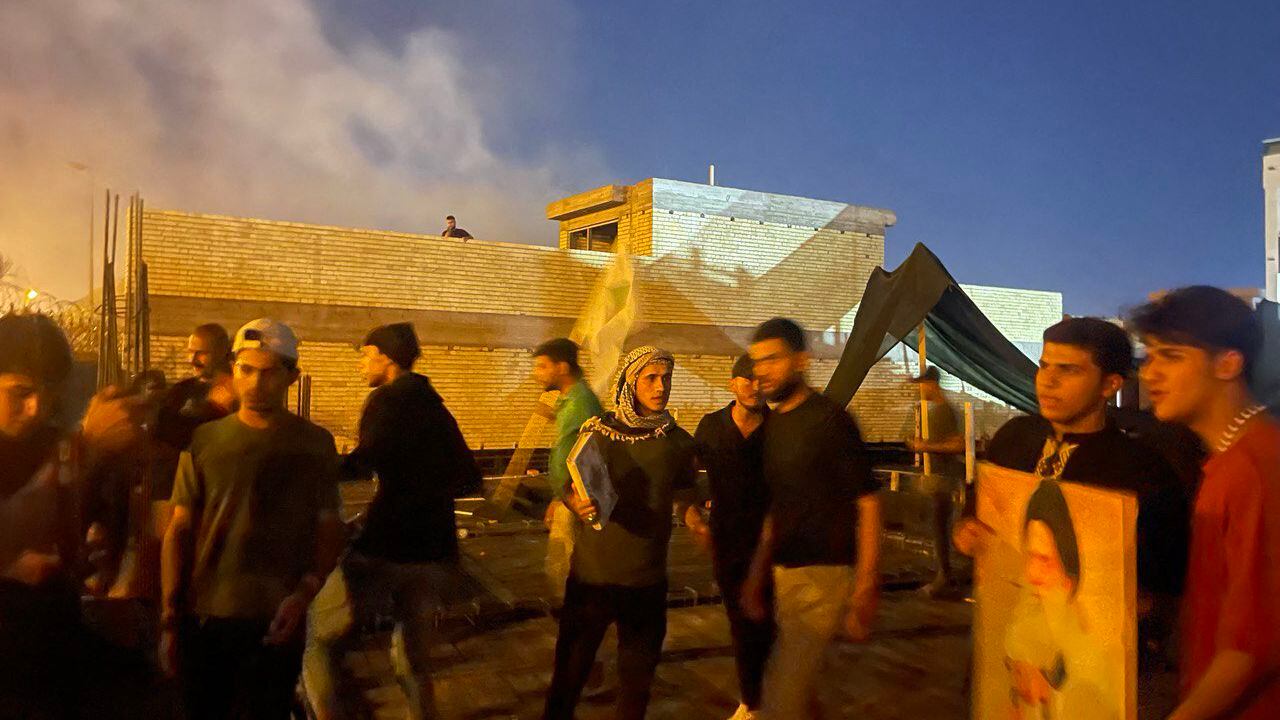 Los manifestantes se paran en lo alto de un edificio junto a la embajada de Suecia en Bagdad el 20 de julio de 2023. Irak condenó el incendio de la embajada de Suecia en Bagdad por parte de los manifestantes, dijo su Ministerio de Relaciones Exteriores, y pidió a las fuerzas de seguridad que identifiquen a los responsables.