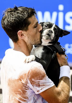 Pedro Cachin festeja la corona dándole un beso a su perro Tango, en la pista del Abierto de Suiza 2023. /Foto: Jean-Christophe Bott/Keystone via AP
