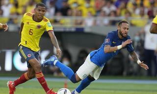 Brazil's Neymar falls, chased by Colombia's Wilmar Barrios, during a qualifying soccer match for the FIFA World Cup Qatar 2022 in Barranquilla, Colombia, Sunday, Oct. 10, 2021. (AP/Fernando Vergara)