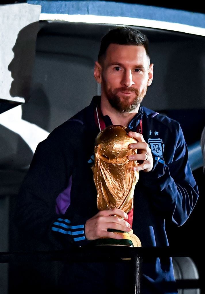 BUENOS AIRES, ARGENTINA - DECEMBER 20:  Lionel Messi holds the FIFA World Cup during the arrival of the Argentina men's national football team after winning the FIFA World Cup Qatar 2022 on December 20, 2022 in Buenos Aires, Argentina. (Photo by Marcelo Endelli/Getty Images)