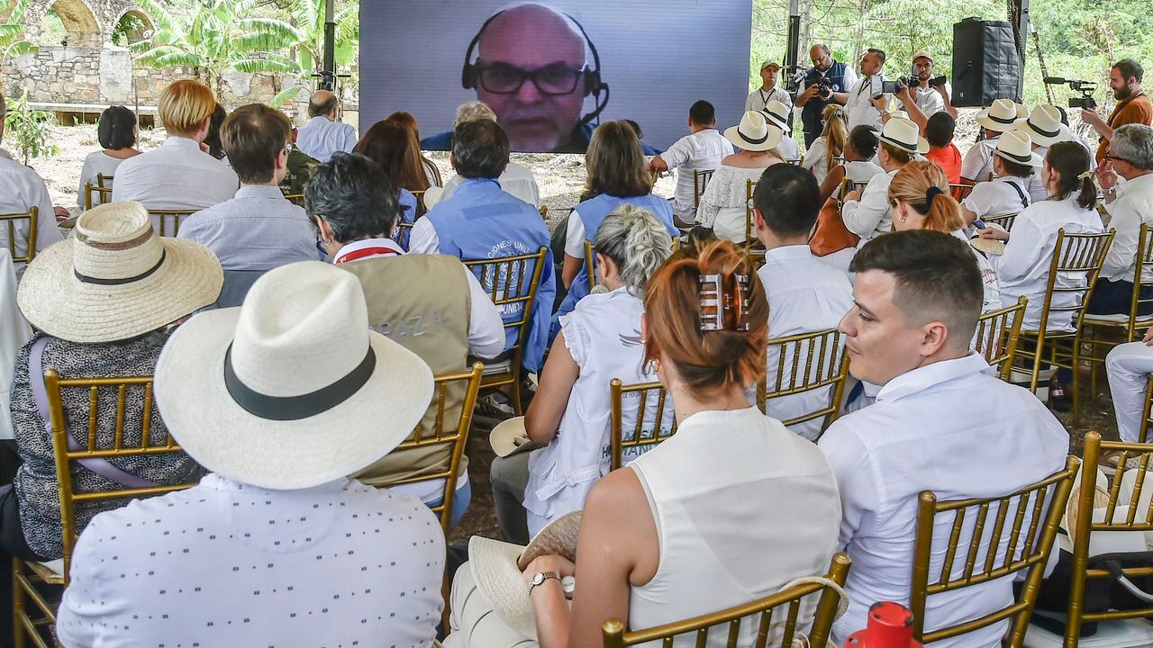 La gente mira una pantalla con la imagen de Salvatore Mancuso, excomandante las AUC durante una ceremonia en una cámara crematoria donde los grupos paramilitares desaparecieron a sus víctimas durante el conflicto armado, en el sector de Juan Frio en el municipio de Villa del Rosario, Colombia el 9 de mayo de 2023.