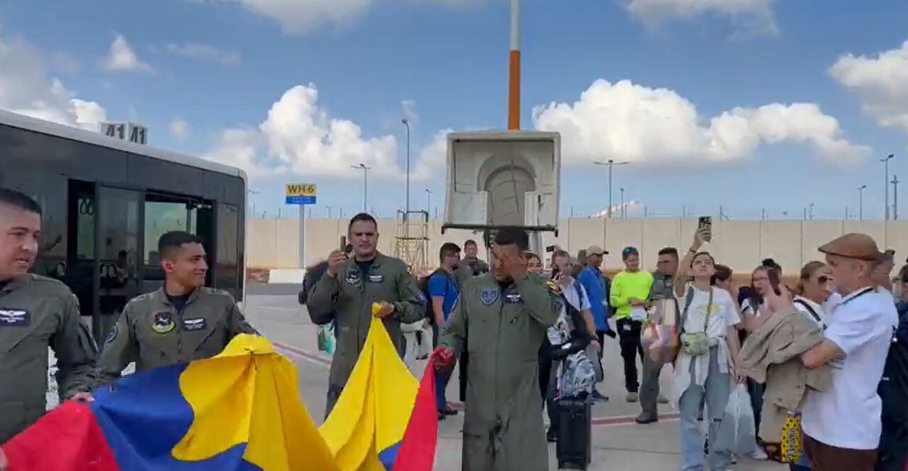 La tripulación descendió del avión con una gran bandera de Colombia.