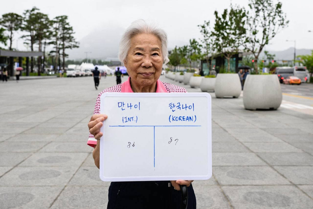 En esta foto tomada en Seúl el 21 de junio de 2023, Lee Kyu-ok posa con una pizarra que muestra su edad internacional, 86, y su edad coreana, 87.