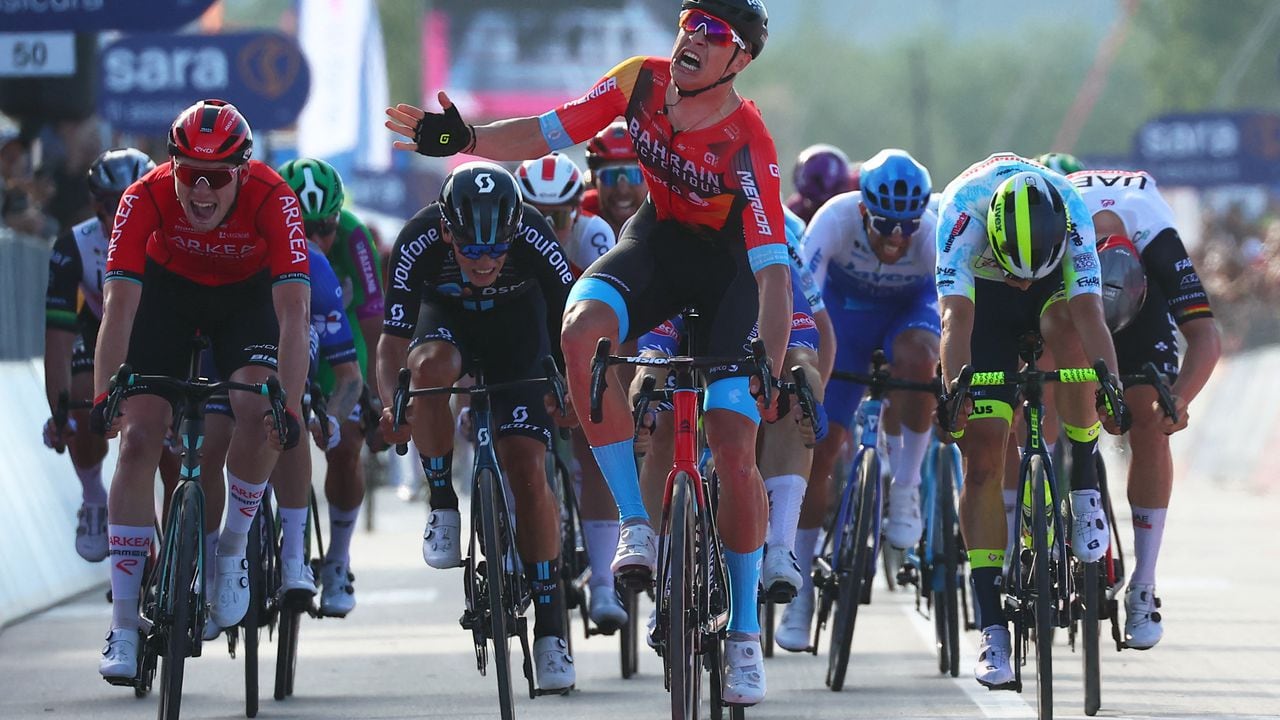 Bahrain - Victorious's Italian rider Jonathan Milan (C) celebrates as he crosses the finish line to win the second stage of the Giro d'Italia 2023 cycling race, 202 km between Teramo and San Salvo, on May 7, 2023. (Photo by Luca Bettini / AFP)
