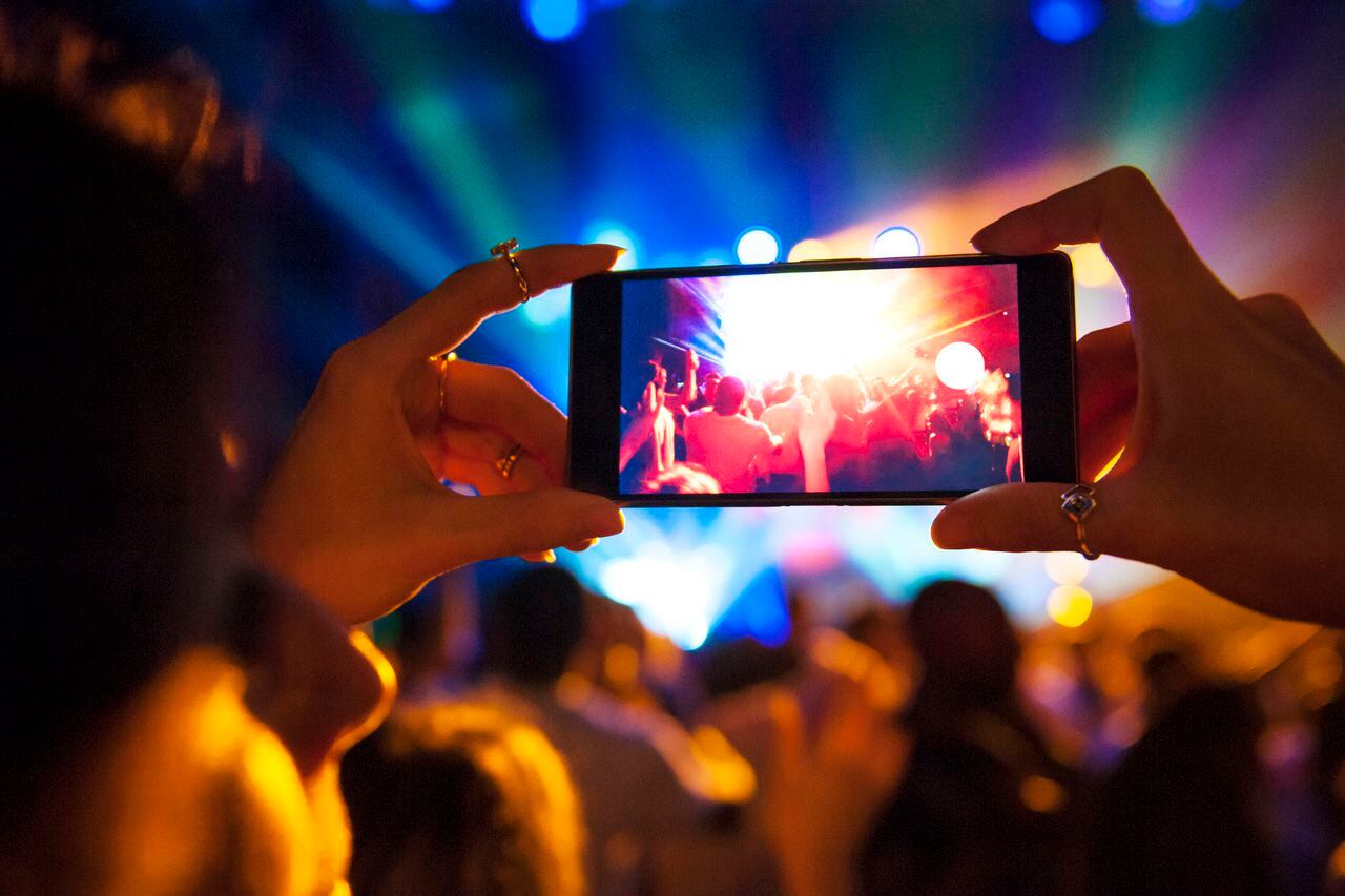 Tomar fotografías con el celular en medio de un concierto es una tarea difícil.