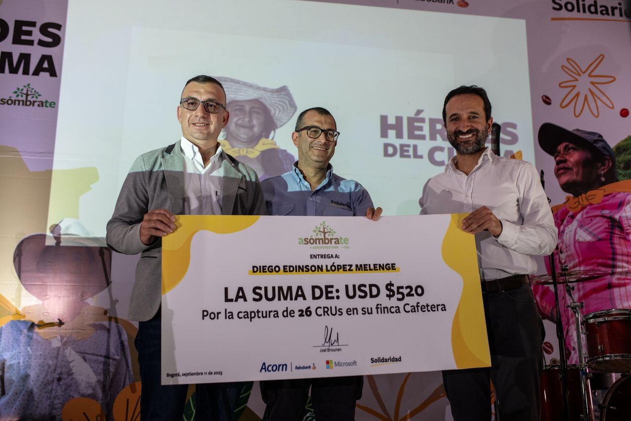 El cafetalero Diego Edison López (izquierda) recibe un cheque de USD$ 520 de manos de Carlos Izasa, gerente del Programa de Café de Solidaridad, y Germán Otálora Castro, Gerente de Operación y Programa de Negocios de Microsoft.