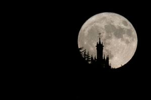 Esta fotografía tomada a última hora del 1 de agosto de 2023 muestra la segunda superluna de 2023, también conocida como la Luna del Esturión, detrás de la iglesia de Santa María la Mayor en Ronda.