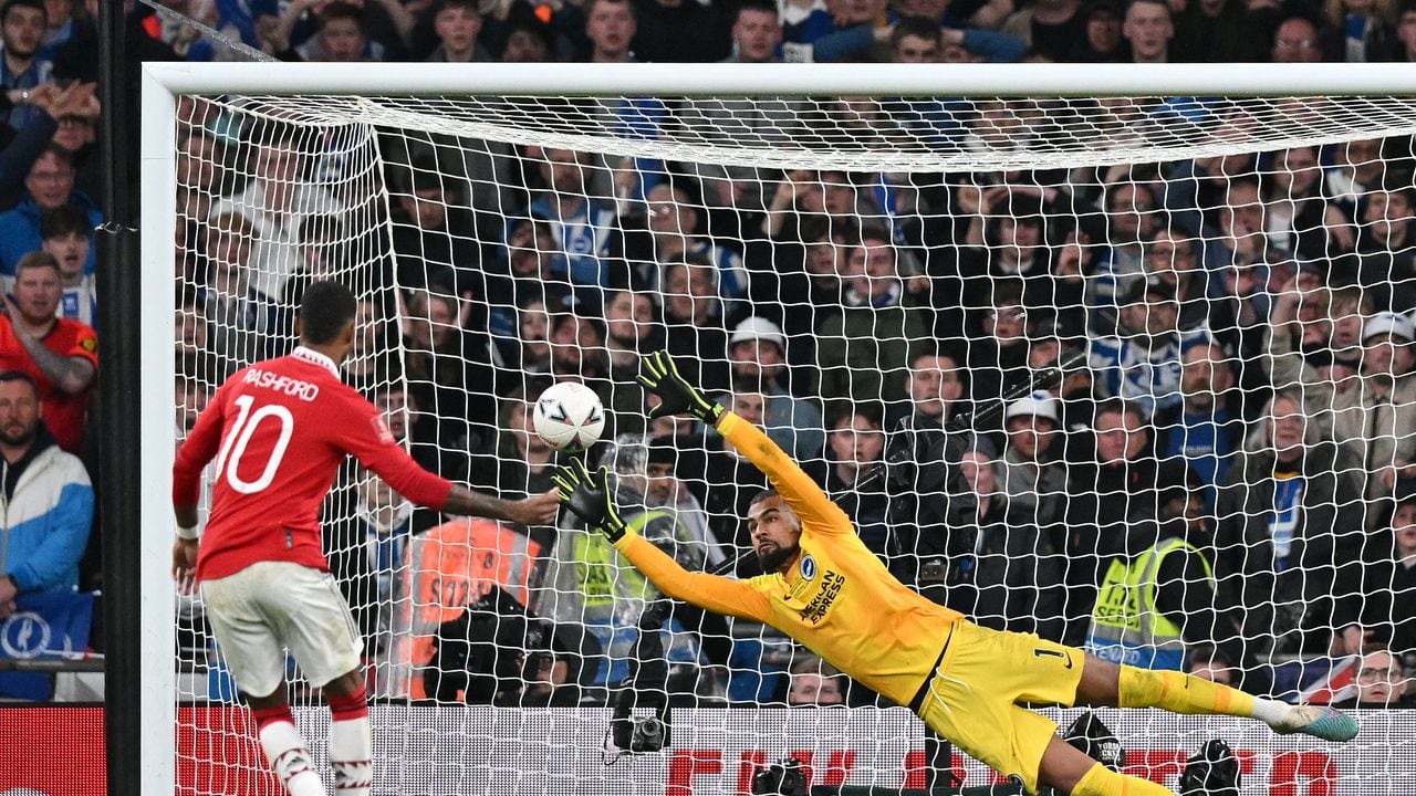El delantero del Manchester United Marcus Rashford anota su penalti superando al portero español del Brighton, Robert Sánchez, en una tanda de penales durante la semifinal de la Copa de Inglaterra.