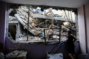 Un niño mira los edificios que fueron destruidos durante los ataques aéreos israelíes en el sur de la Franja de Gaza el 1 2023 de noviembre en Khan Yunis, Gaza. Al entrar en la tercera semana del conflicto, el ejército israelí ha ampliado su asalto militar.  (Photo by Ahmad Hasaballah/Getty Images)