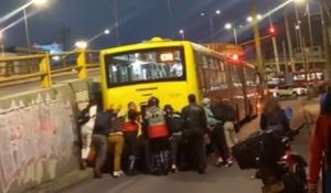 Un vehículo quedó varado en Bogotá y sus pasajeros tuvieron que empujarlo.