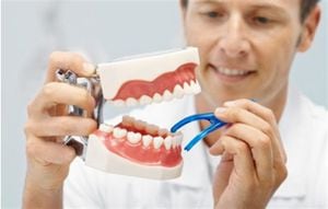 doctor con uan dentadura en la mano, foto: thinkstock