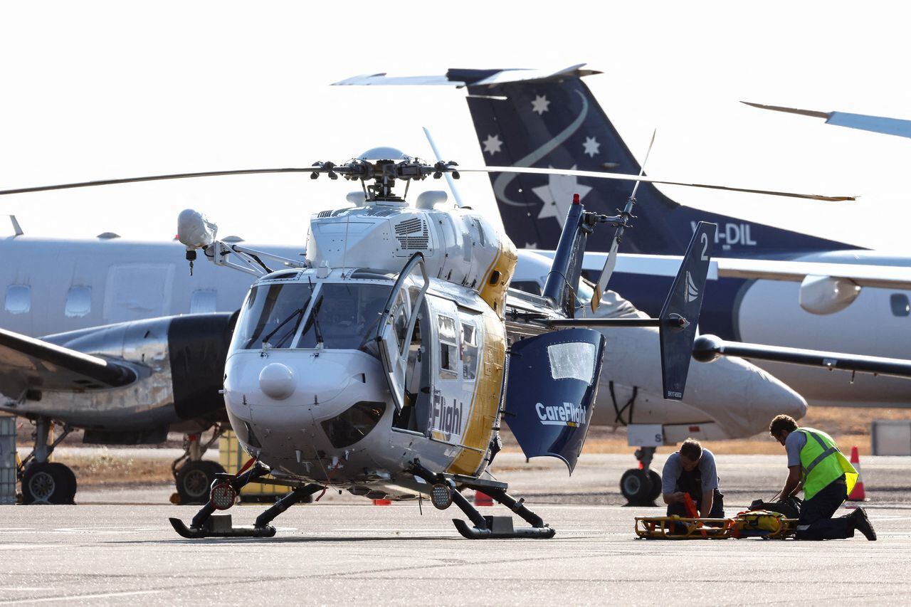Se ve un helicóptero Care Flight en la pista del Aeropuerto Internacional de Darwin en Darwin el 27 de agosto de 2023, mientras se realizan trabajos de rescate para transportar a los heridos en el accidente del avión militar estadounidense Osprey en una isla remota al norte del continente de Australia.