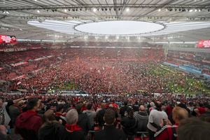 Aficionados del Bayer Leverkusen celebran después de que el equipo confirmó el título de la Bundesliga con la victoria ante Werder Bremen el domingo 14 de abril del 2024.  (David Inderlied/dpa via AP)