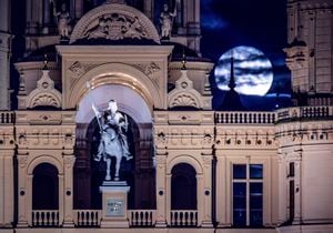 A supermoon rises over the Schwerin castle in Schwerin, Germany, Tuesday, Aug. 1, 2023. The cosmos is offering up a double feature in August: a pair of supermoons culminating in a rare blue moon on Aug. 30. (Jens Büttner/dpa via AP)