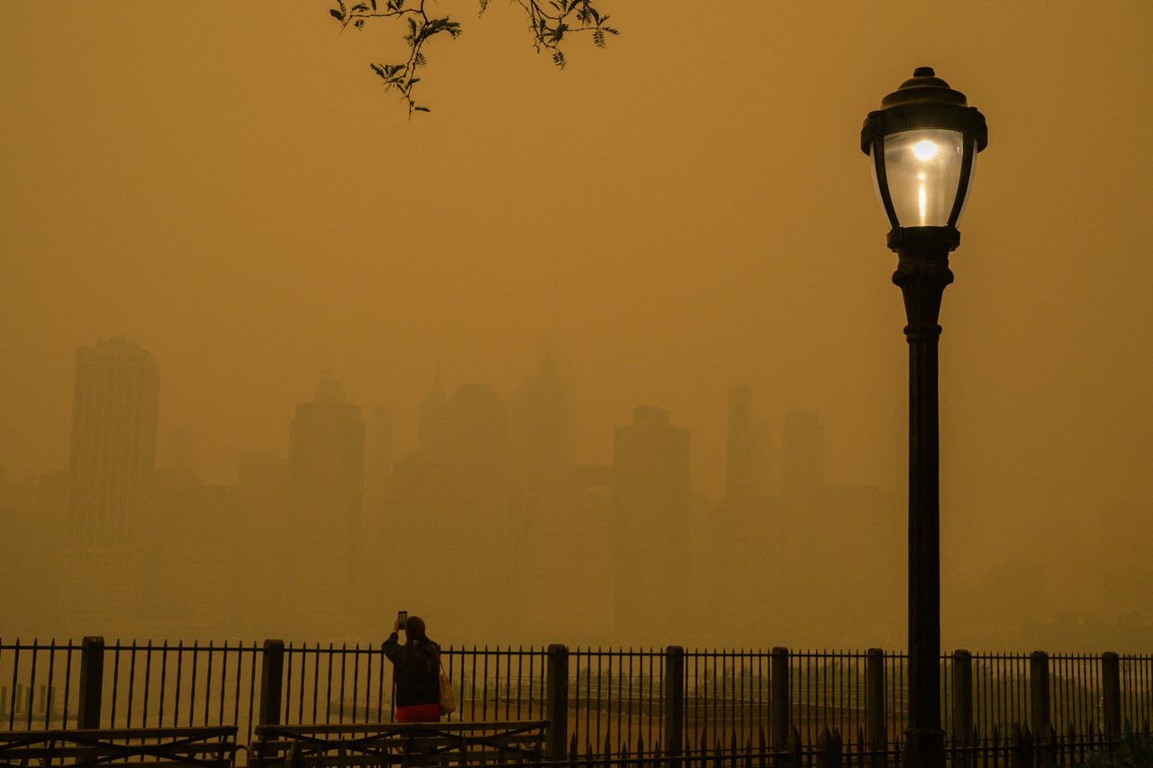Una persona toma fotos del horizonte mientras el humo de los incendios forestales en Canadá causa condiciones de niebla en la ciudad de Nueva York el 7 de junio.