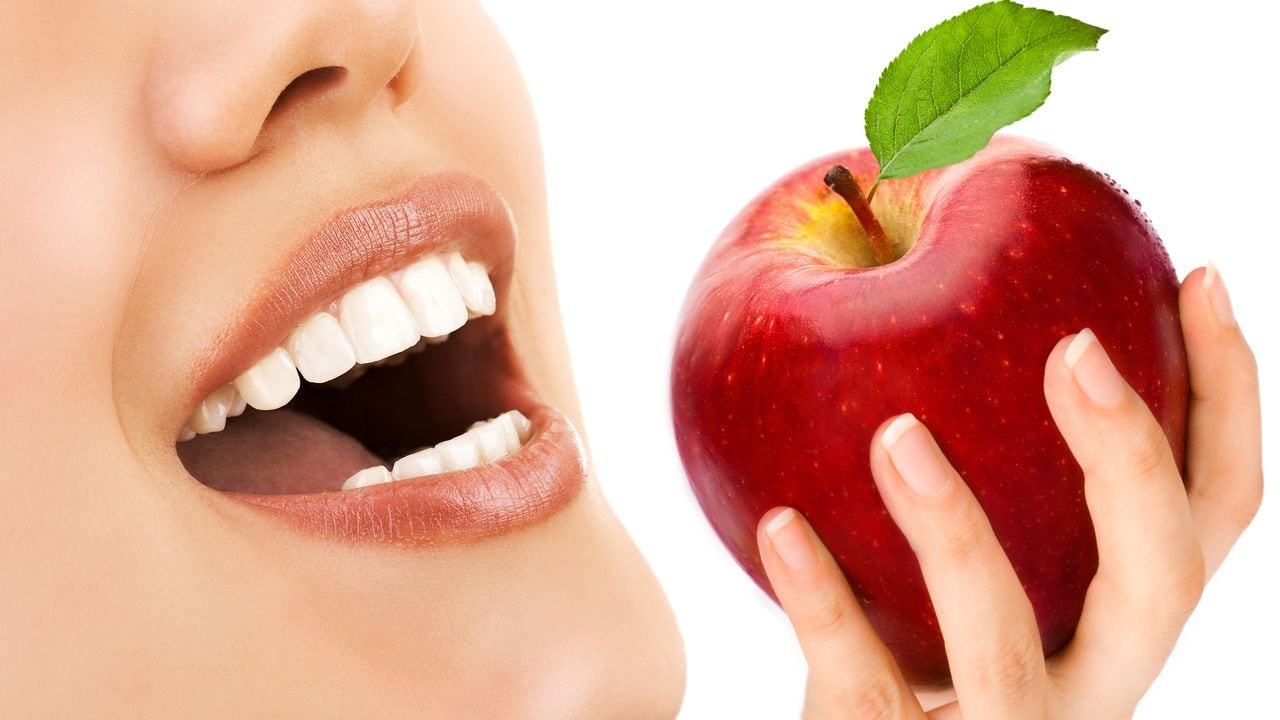 Los dientes de una mujer y una manzana