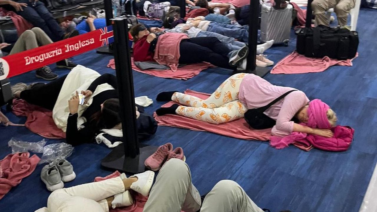 Los viajeros se encuentran durmiendo en el piso a la espera de alguna información.
