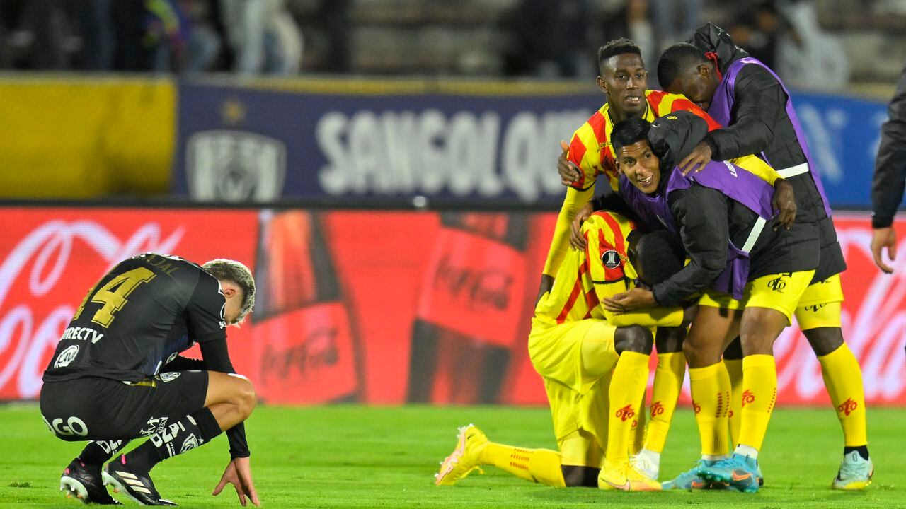 Jugadores del Pereira celebran su clasificación, ante la trsiteza de un futbolista del equipo ecuatoriano.