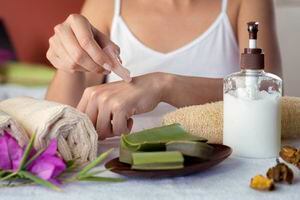 Hispanic young woman moisturizing hands with aloe vera natural gel