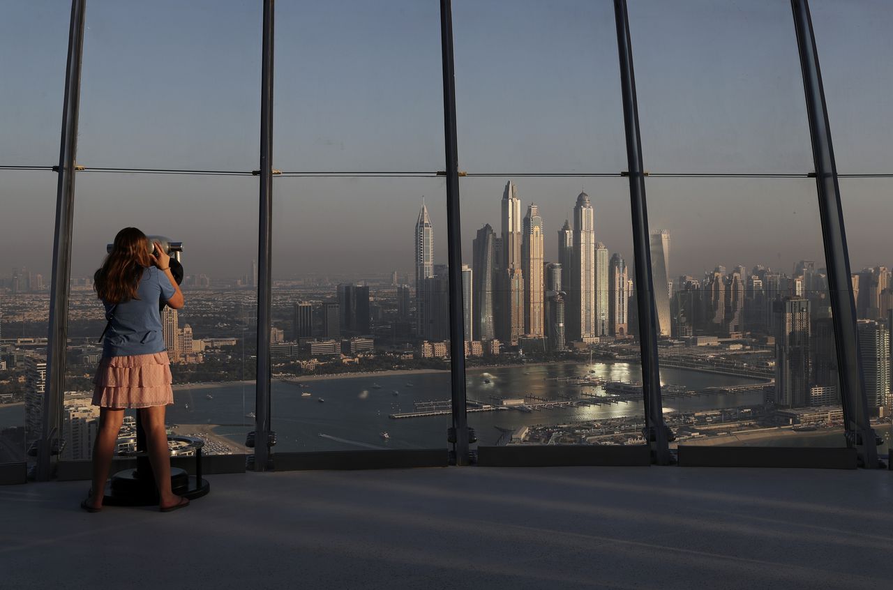 Una mujer observa la vista de las torres del distrito de Marina desde la plataforma de observación de "The View at The Palm Jumeirah" en Dubai, Emiratos Árabes Unidos. (AP Photo / Kamran Jebreili)