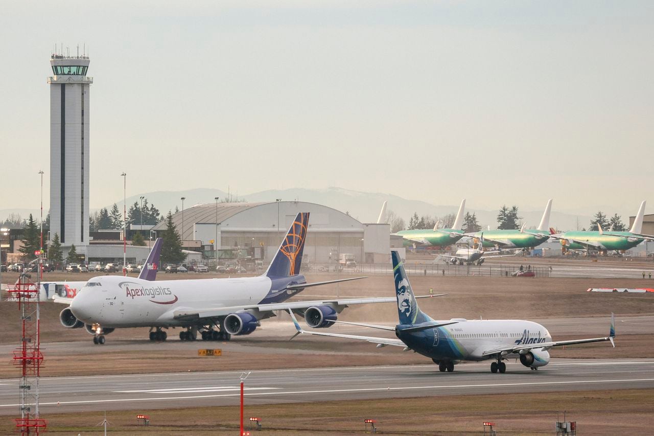Un avión Boeing 737-800 de Alaska Airlines, a la derecha, despega como el último avión 747 producido por Boeing, un carguero 747-8 para Atlas Air, taxis antes de despegar desde Paine Field en Everett, Washington, el 1 de febrero de 2023. (Imagen de referencia)