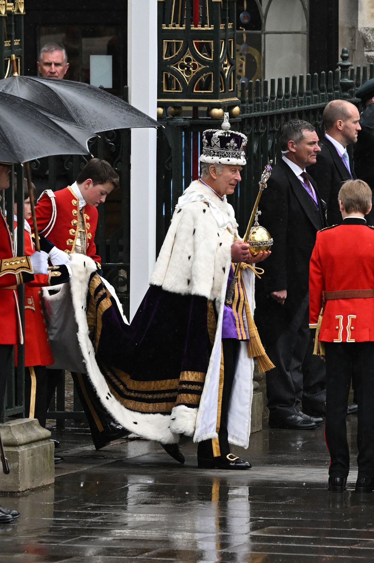 Carlos III sale de la ceremonia de la coronación en medio de la lluvia.