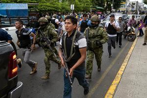 Soldados y policías avanzan detrás de un vehículo blindado mientras seguidores del candidato presidencial Daniel Noboa asisten a un acto político con el aspirante en la ciudad de Esmeraldas, Ecuador, el viernes 6 de octubre de 2023. Ecuador asistirá a la segunda vuelta presidencial el 15 de octubre.