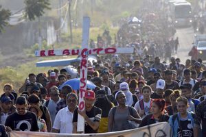 Migrantes que caminan por la carretera llevan una cruz que dice en español "Cristo Resucitado" durante la Semana Santa mientras avanzan por Tapachula en el estado mexicano de Chiapas, el lunes 25 de marzo de 2024.